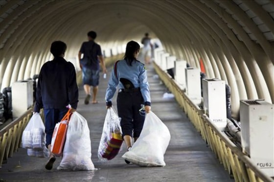 Flood victims make their way down the tunnel after being ordered to evacuate from the flood relief center at Don Muaeng airport in Bangkok, Thailand, on Saturday.
